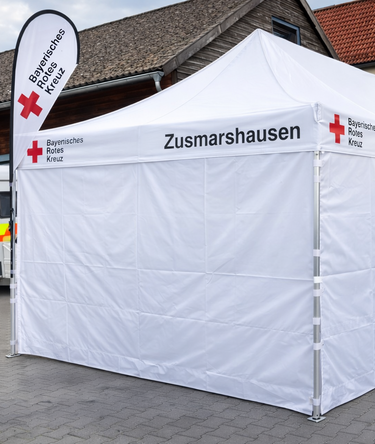White pop up gazebo 8x4 m with closed side-panels and side-panels with windows. Personalised with the logo of the bavarese red cross.